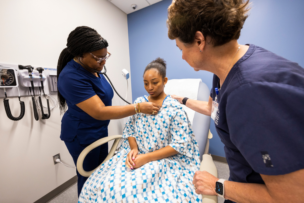 patient in a hospital bed being examined by medical personnel