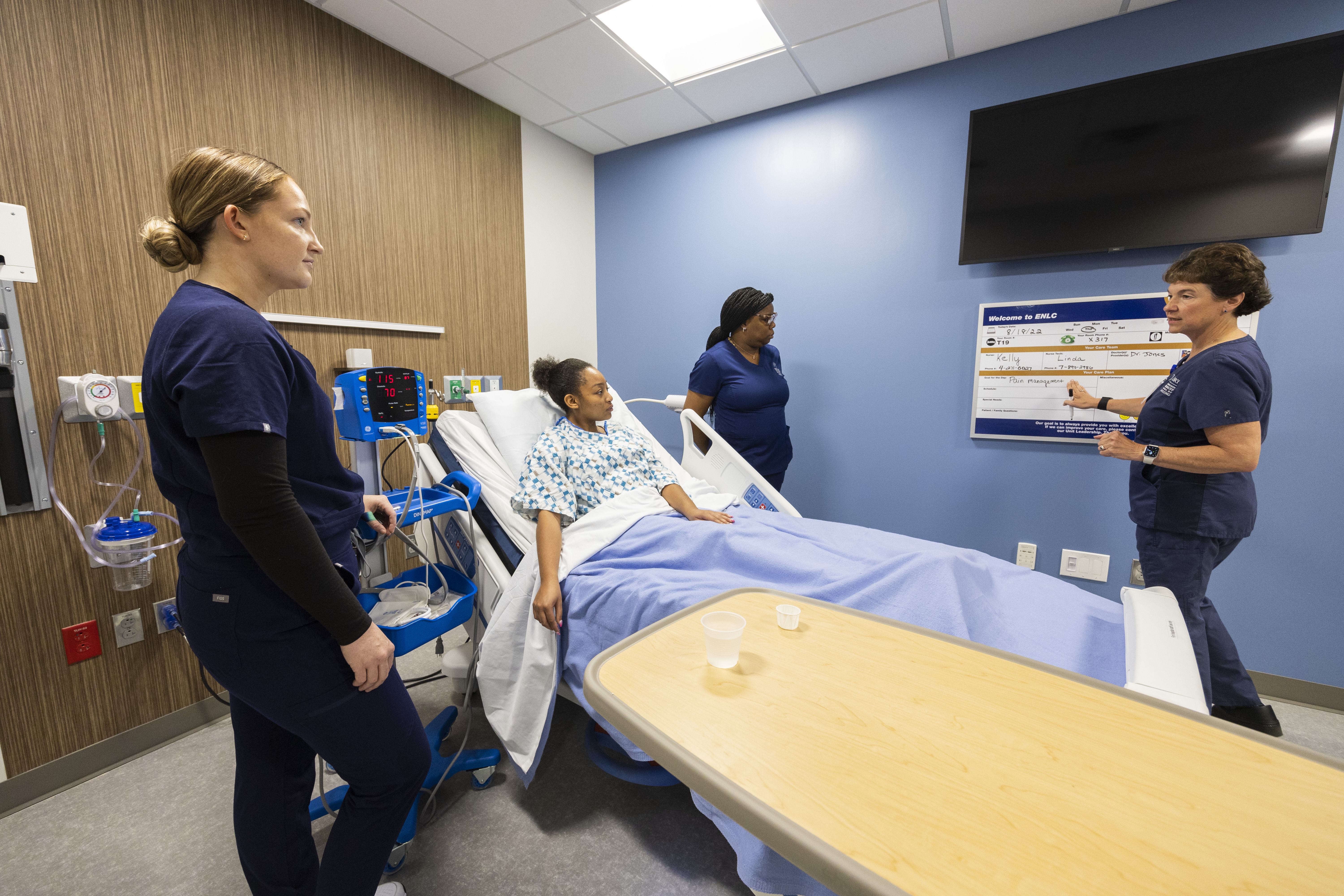 patient in hospital bed being treated by nurses